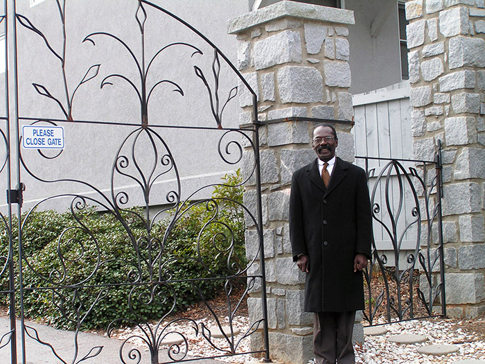 Councilman Davis at a hand-made ornamental gate by black craftsmen, Columbia Historic Sites