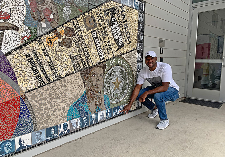 Austin Tours' Javier Wallace at Rhapsody in Austin mural aside African America Cultural Facility